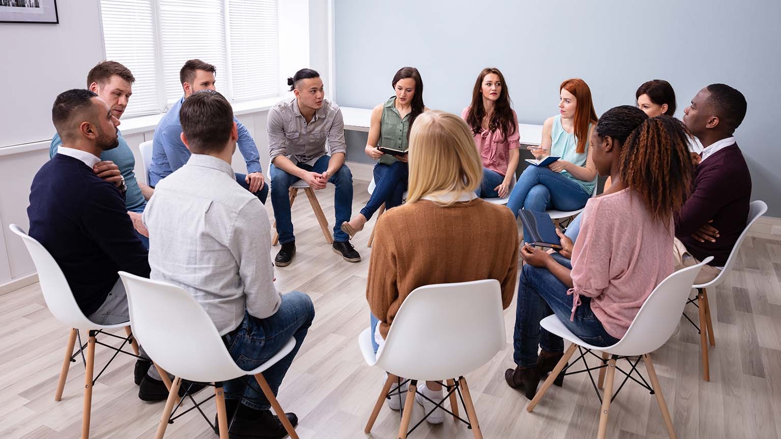 Diverse group sitting in a circle practicing the key conditions of successful and respectful dialogue