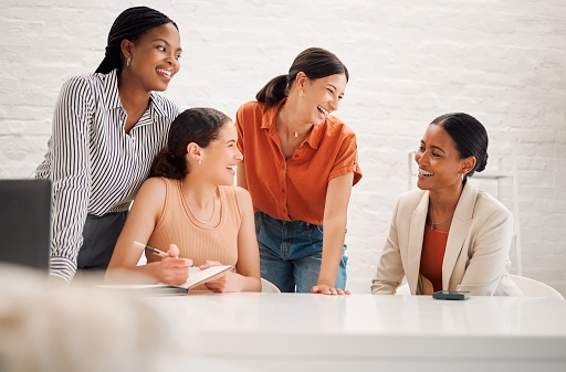 A diverse group of female colleagues practicing sharing their professional accomplishments together